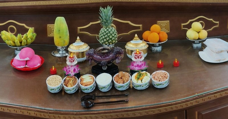Incense, lamps, fruits, and food offered in homage to the Buddha.